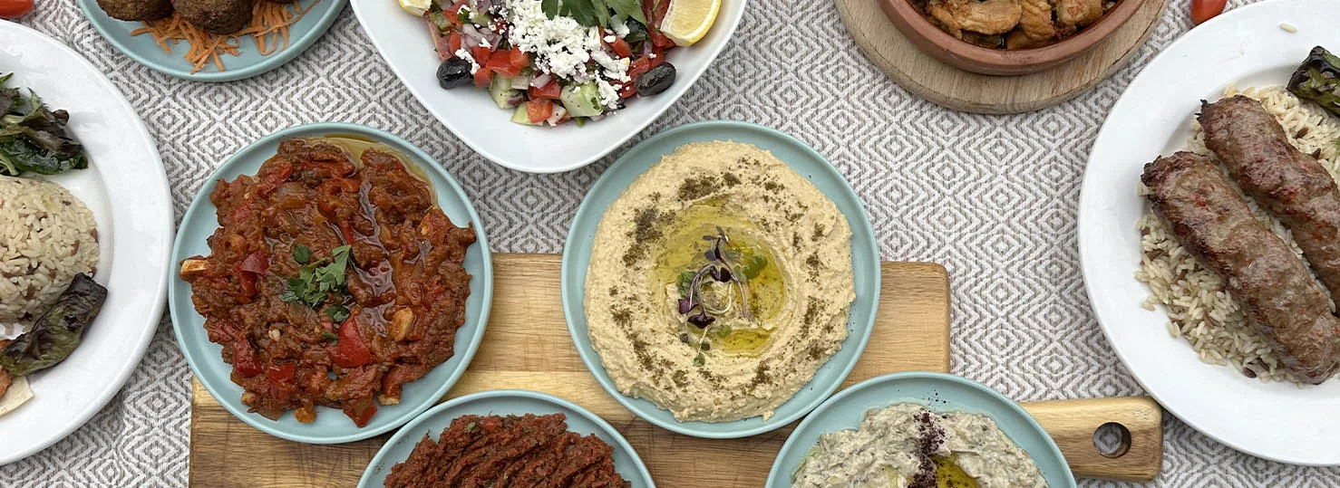Overhead spread of mezes, salads, and kebab plates on the Zaytin table
